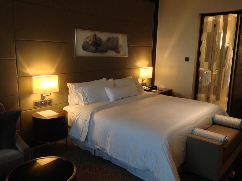A guest room with a large bed and soft lighting